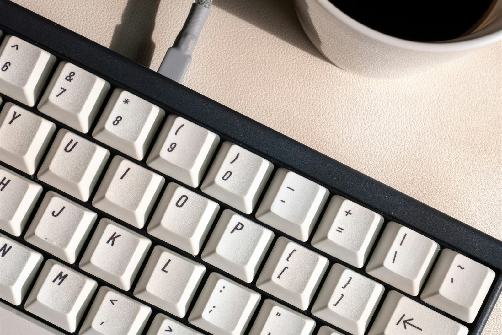 Main humaine sur clavier dans une lumière dorée du matin, illustration de la collaboration entre intelligence humaine et IA dans la rédaction de communication d'entreprise